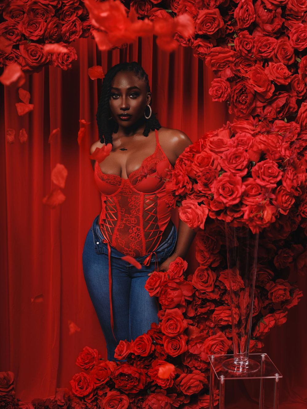Artistic portrait series in deep red lighting with roses and denim fashion against dramatic crimson backdrop.