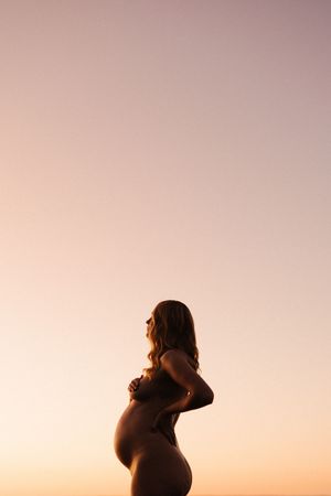 Silhouette of someone against a pink and purple sunset sky creating a peaceful and ethereal atmosphere.