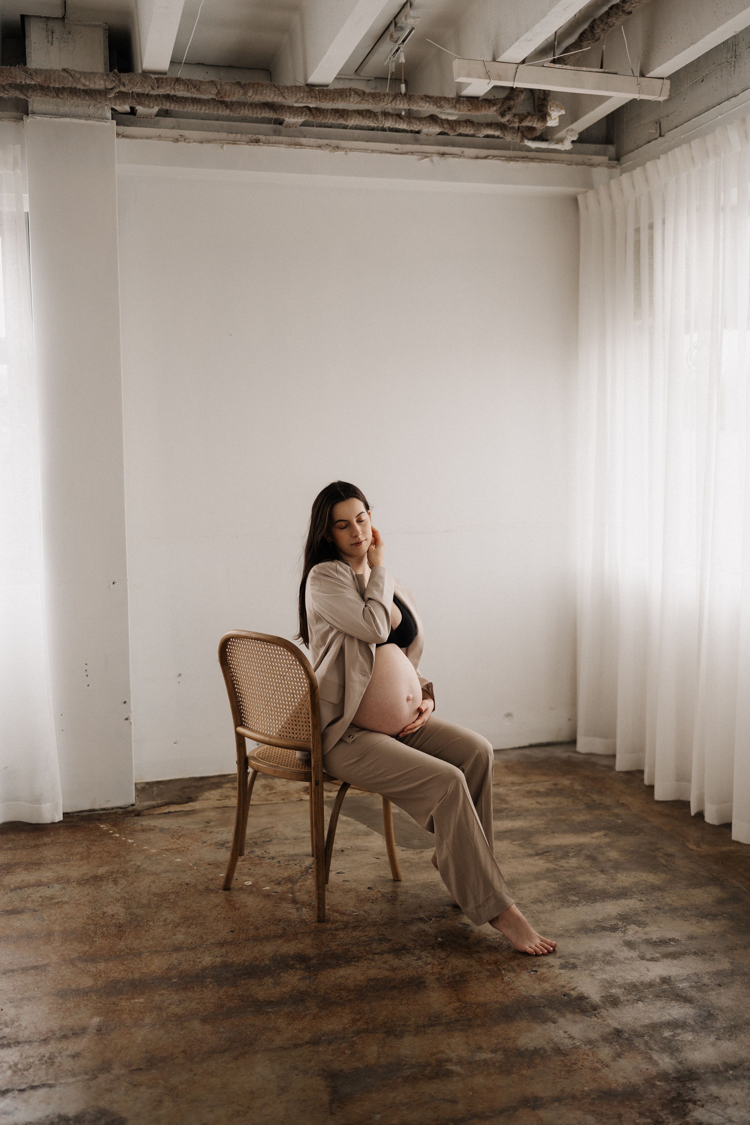 A minimalist photo series showing a person in beige loungewear sitting in different positions on an antique chair.