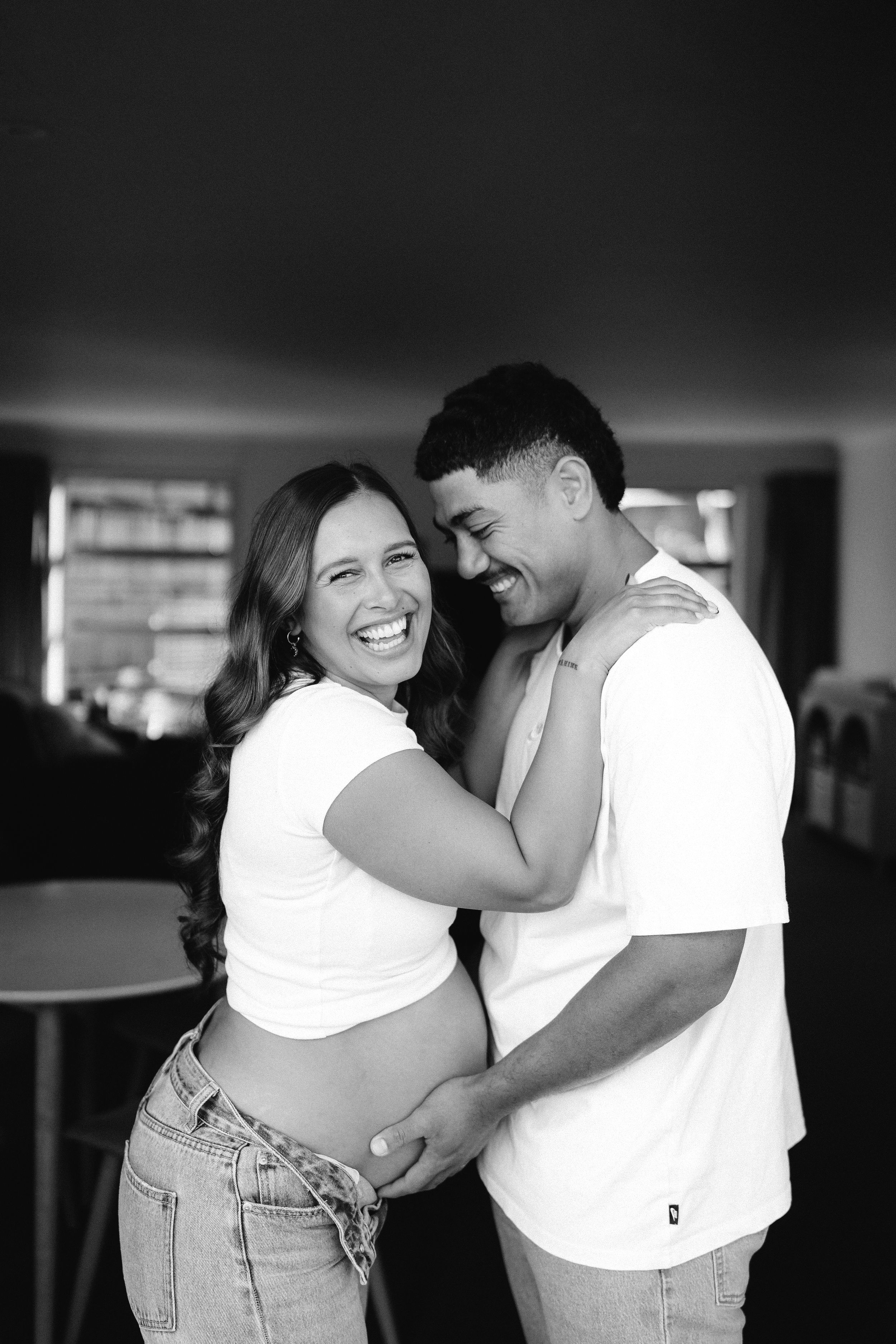 A romantic black and white photo series showing intimate moments between a couple in casual white shirts and denim.
