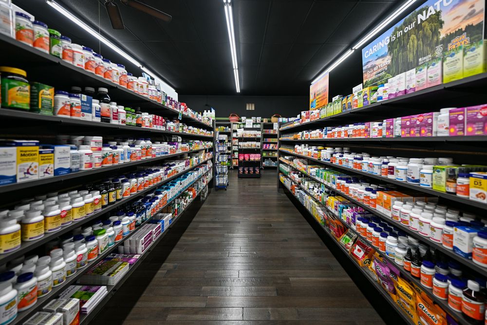 Well-stocked health supplement store aisle with colorful vitamin and nutrition product bottles on dark wood shelves.