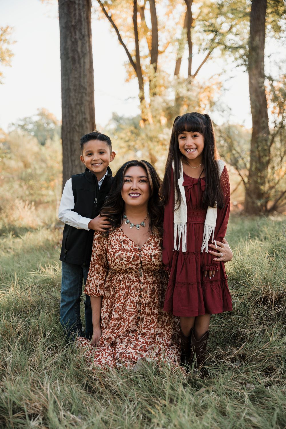 Family gathered together for casual portraits in a wooded setting with natural light.