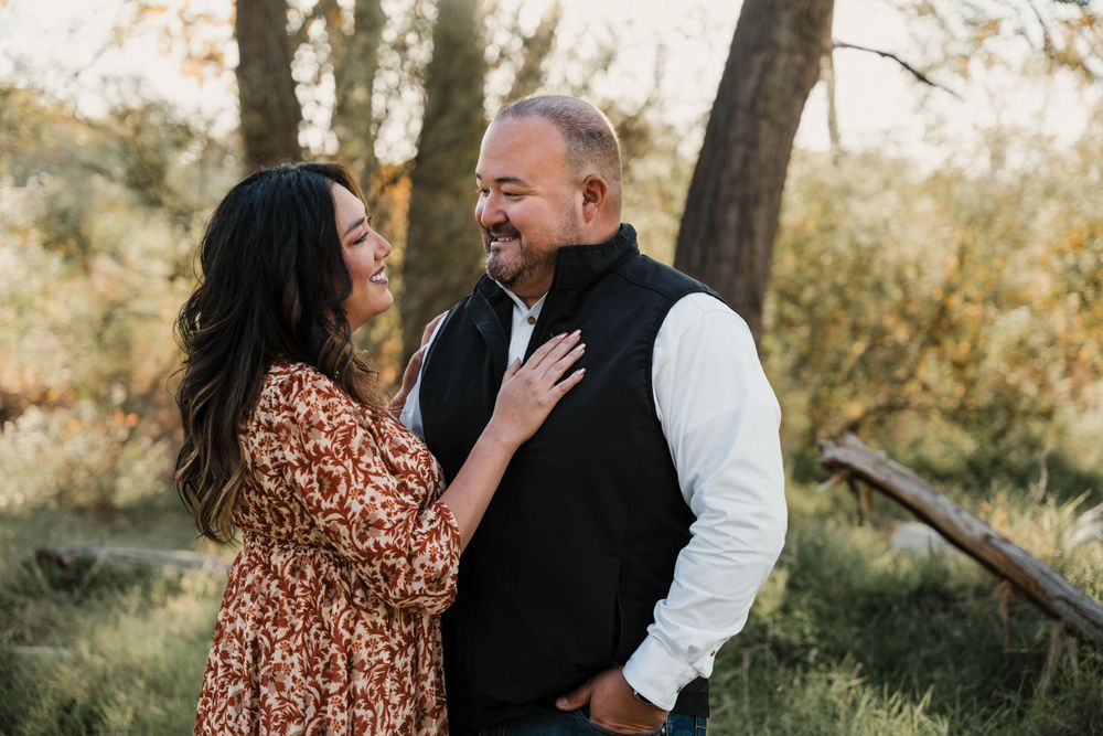 Couple sharing intimate laughs during an outdoor photoshoot with golden sunlight.