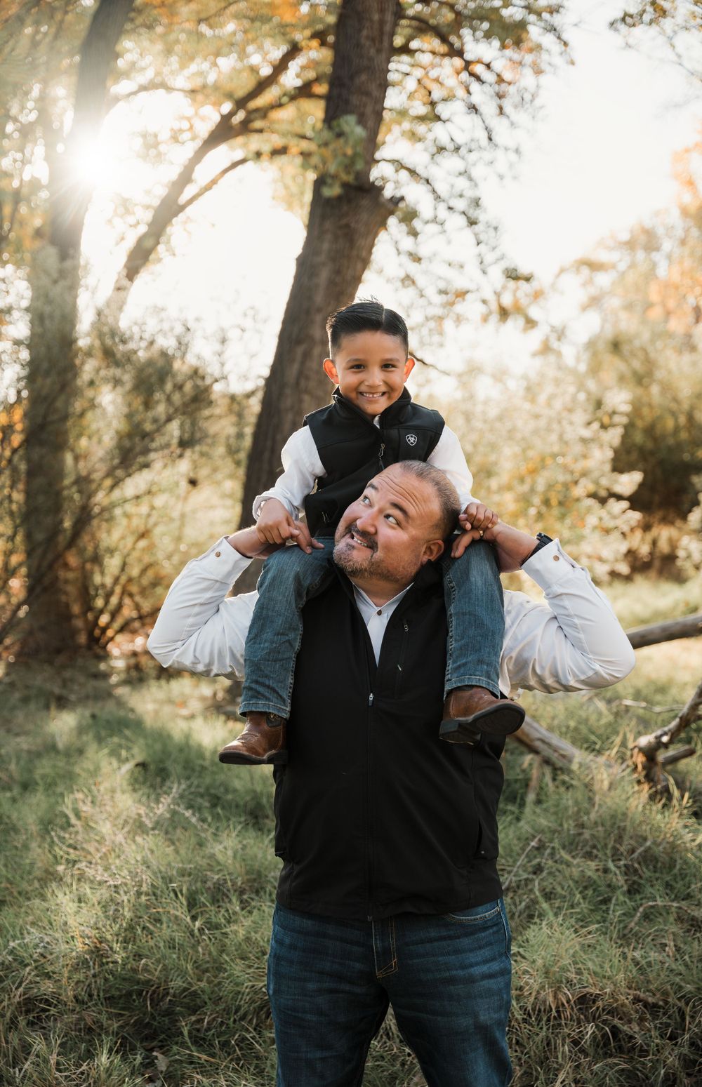 Joyful shoulder ride moment between two people during outdoor autumn photoshoot.