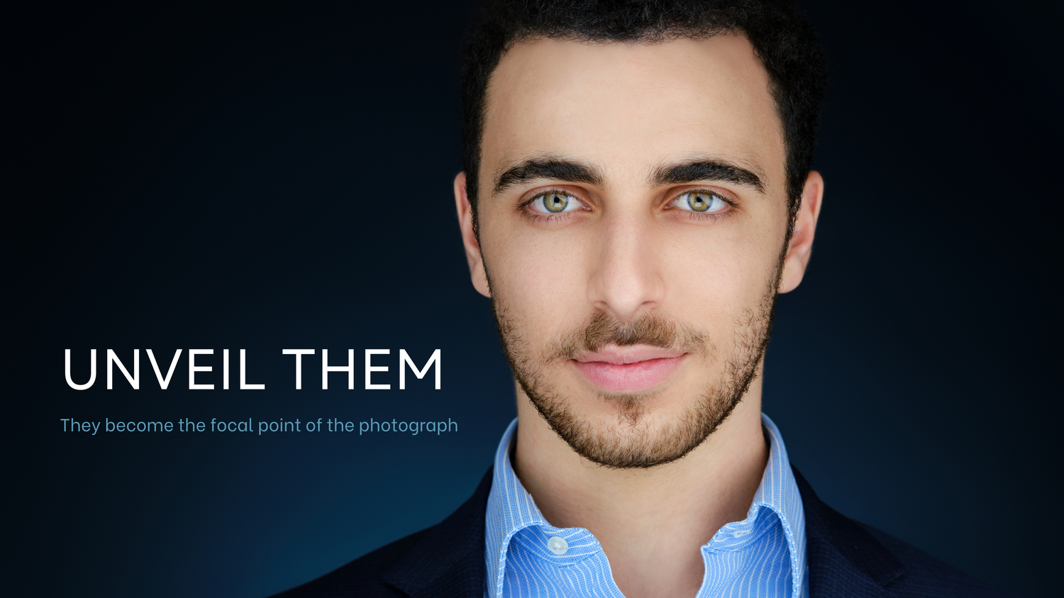 Professional headshot of a young man with light eyes in a blue suit against a dark background.