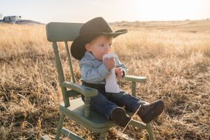 Rustic outdoor scene with vintage green chair in golden wheat field.