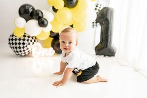Festive party setup with black and yellow balloons featuring checkered accents and decorative elements.