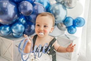 Blue and chrome balloon decorations and party setup with cake and number one centerpiece for first birthday celebration.