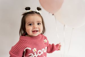 A collection of four photos shows someone wearing a cozy pink turtleneck sweater in different poses.
