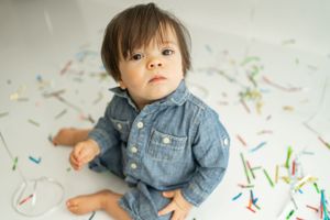 Candid portrait against white background with colorful confetti scattered below.