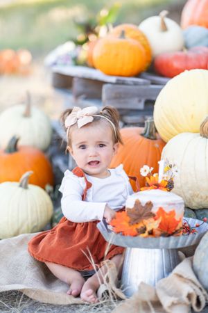 Autumn pumpkin patch scene with rustic metal decor and fall leaves.