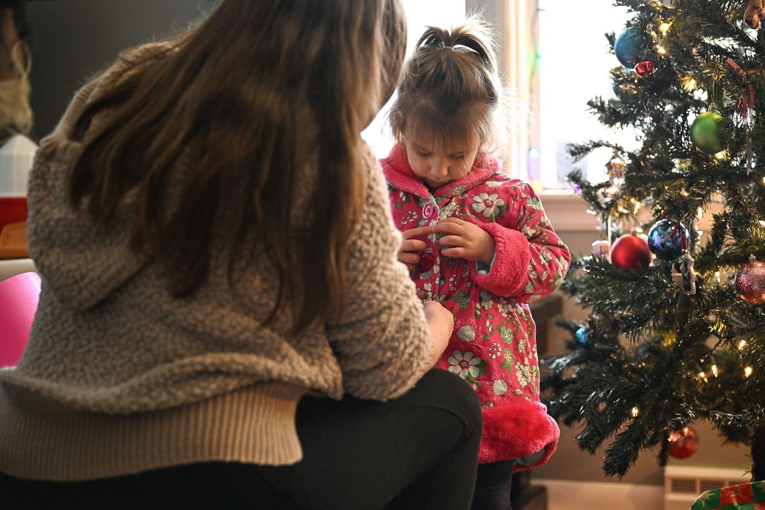Amber helps her daughter put on her coat