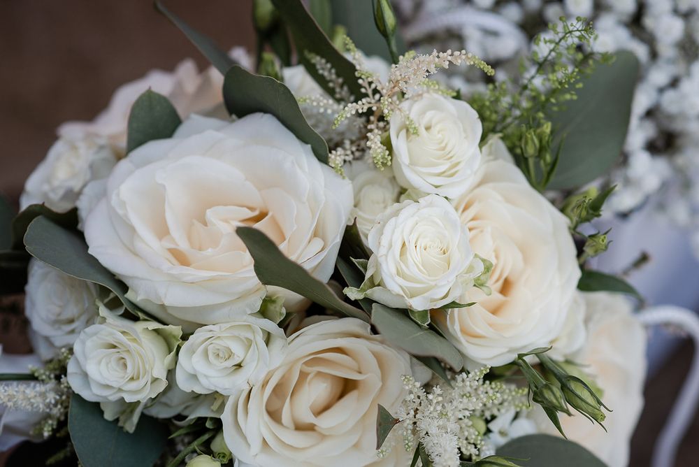 Elegant white rose and eucalyptus wedding bouquet with delicate details.