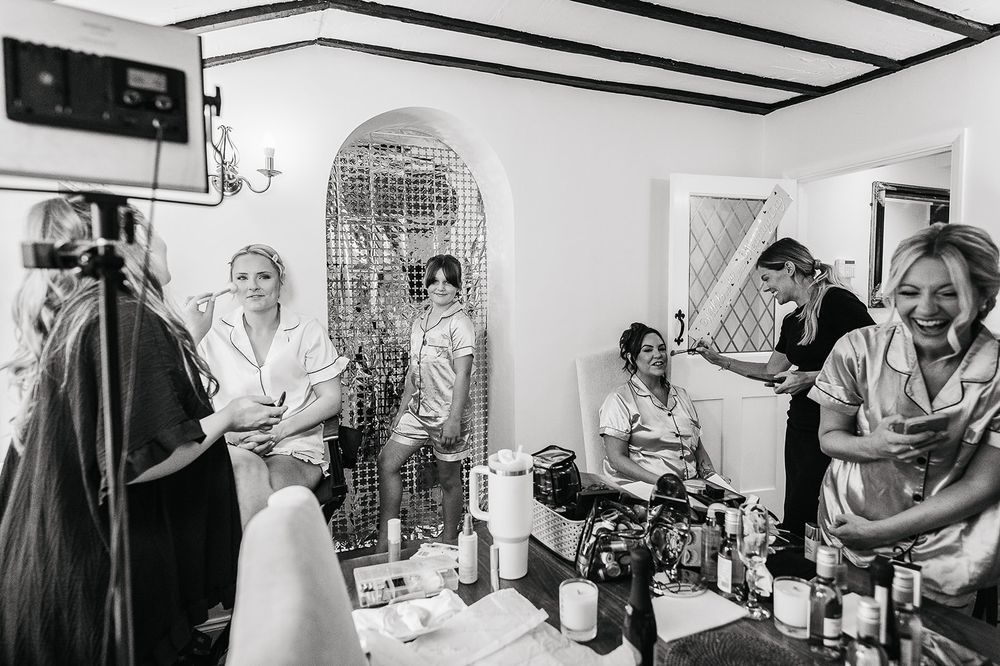 Busy morning scene of wedding preparations in bright dressing room.