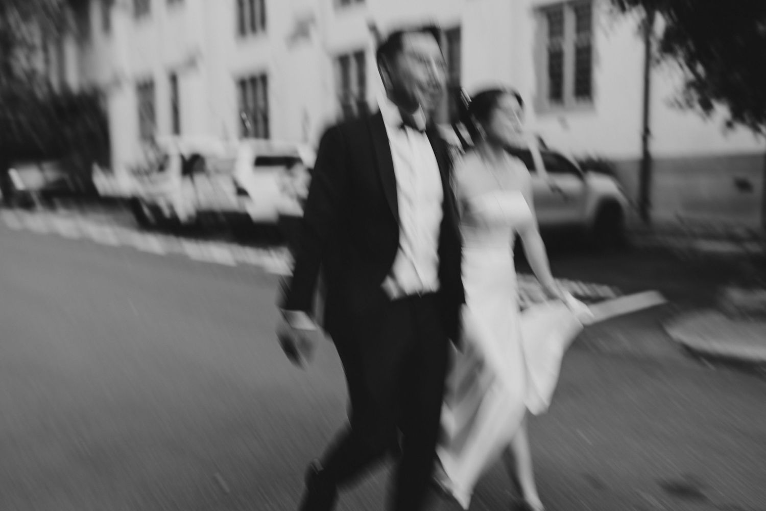 Artistic blurred black and white photo of couple walking outdoors.