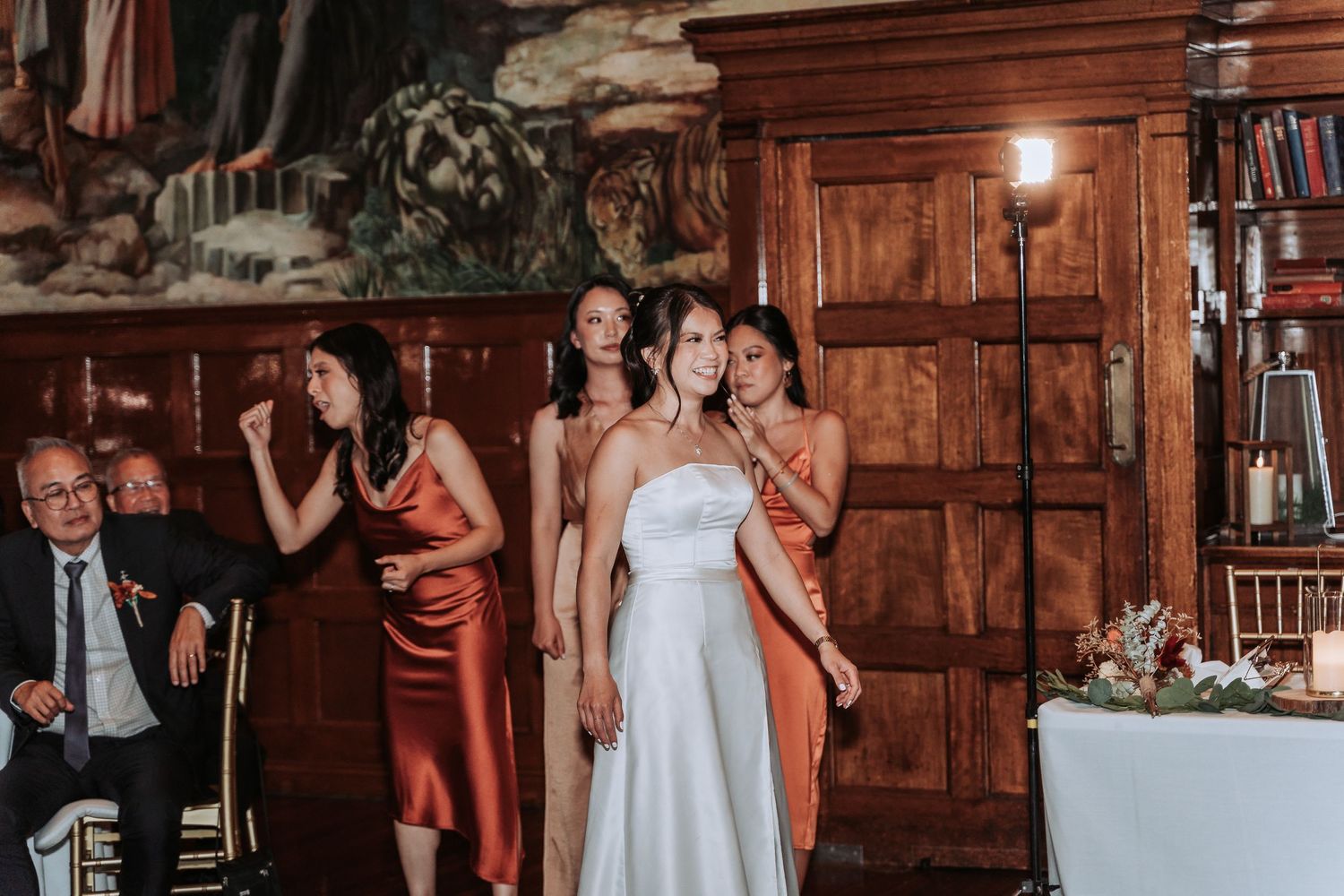 Wedding celebration in rustic wood-paneled room with elegant decor.