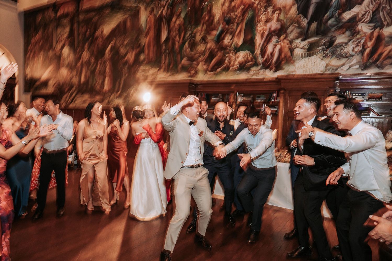 Energetic wedding reception dancing with guests celebrating in a beautifully lit venue.