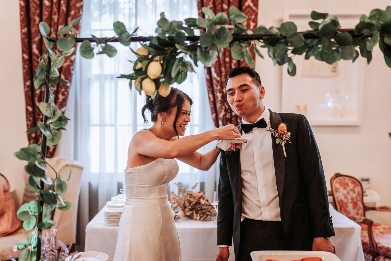 Wedding celebration under greenery and lemon decorations in an elegant indoor setting.