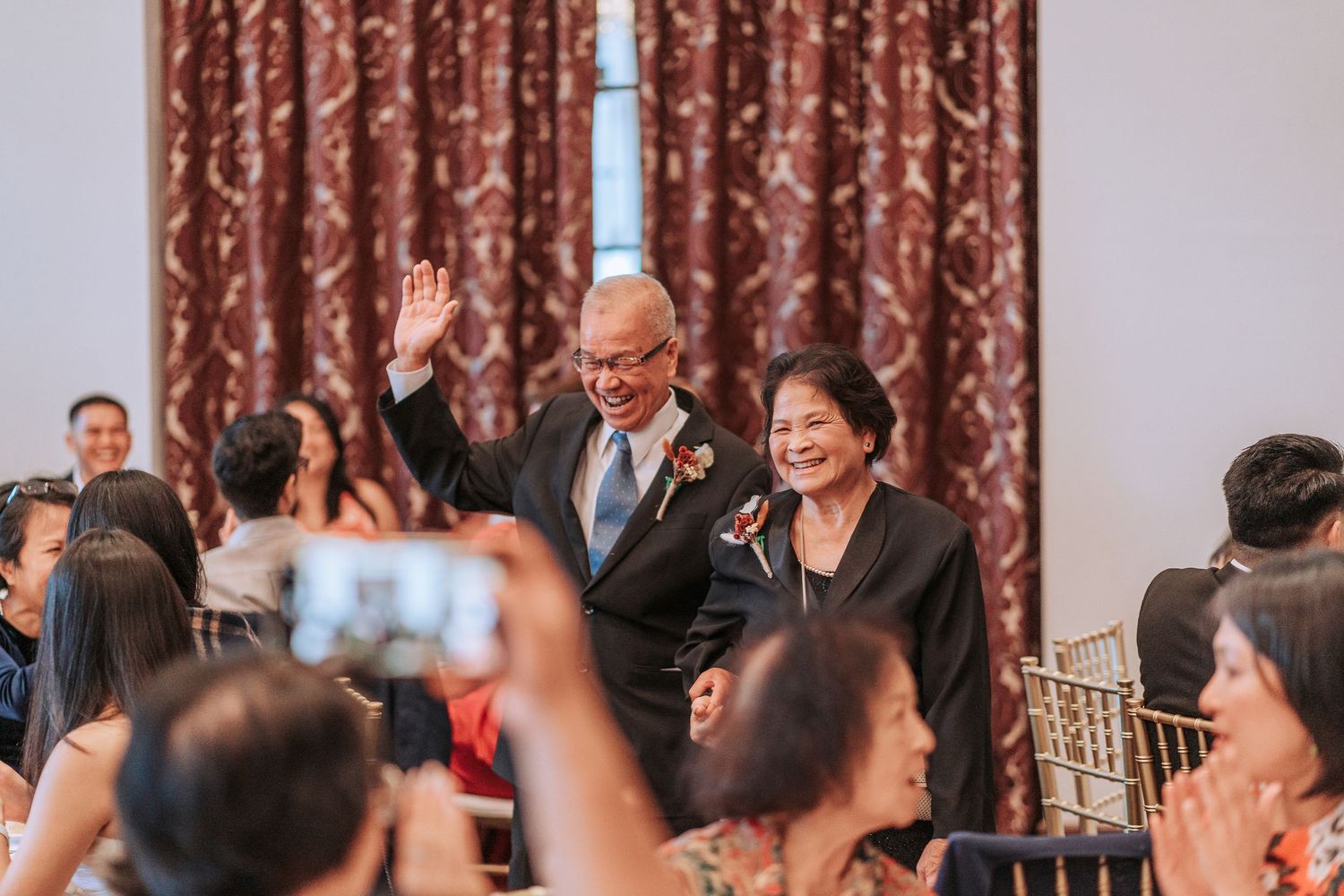 Guests taking photos during a celebratory moment at a wedding reception.