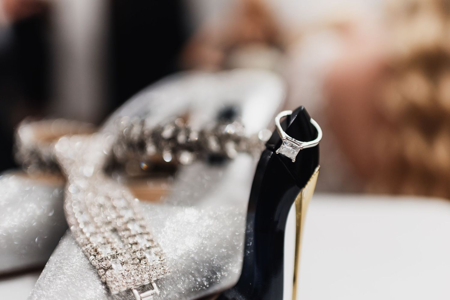 Close-up macro shot of a diamond ring with jewelry crafting tools in soft focus.