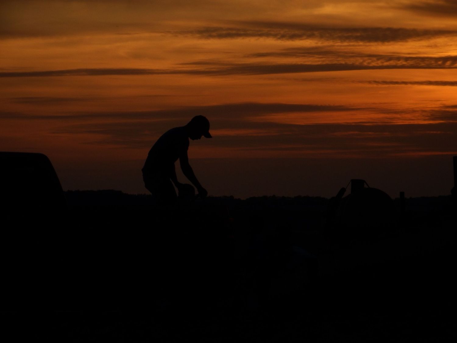 A silhouetted figure against an orange sunset sky creates a contemplative scene.