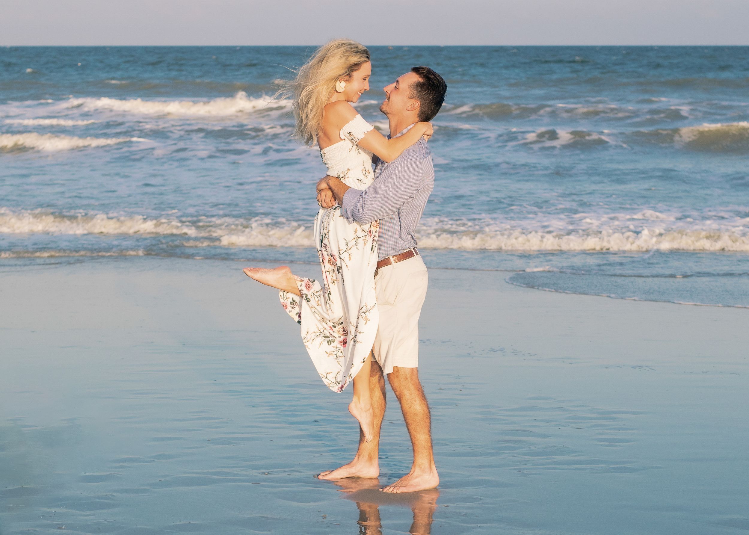 Playful couple dancing on the beach laughing during sunset photo session, captured by Tasha Cannaday Photography, serving Essex-County.