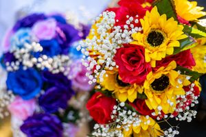 Vibrant wedding bouquets featuring sunflowers, red roses, and baby's breath blooms.