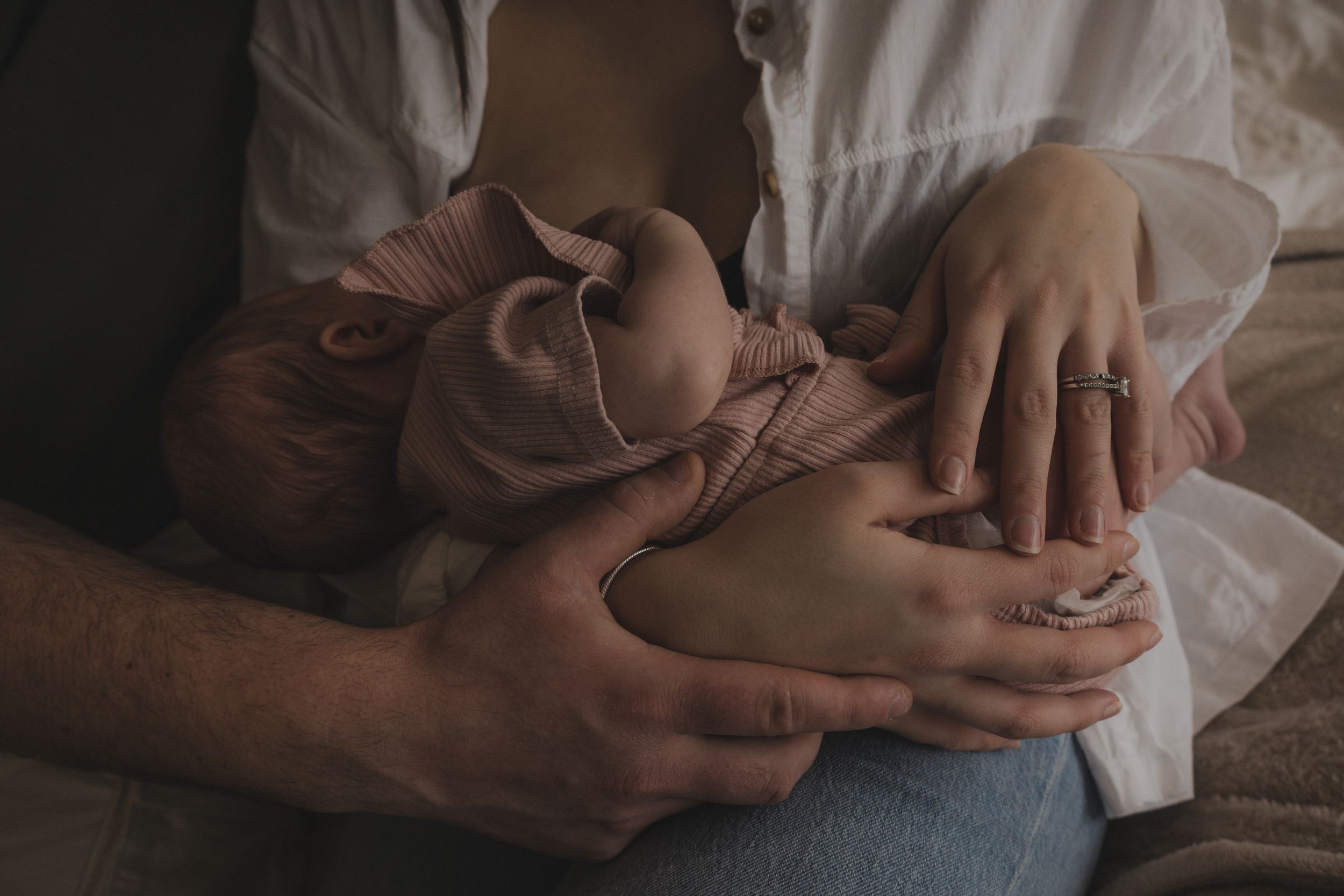 close up of baby in parents arms,newborn lifestyle session in Thetford, muted tones, soft light