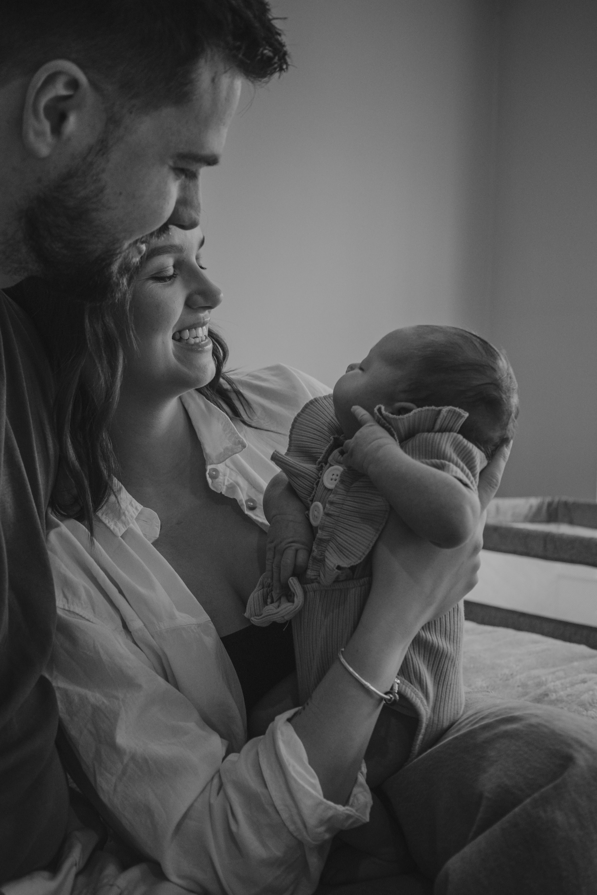 newborn baby in parents arms,newborn lifestyle session in Thetford, muted tones, soft light, monochrome,smiling