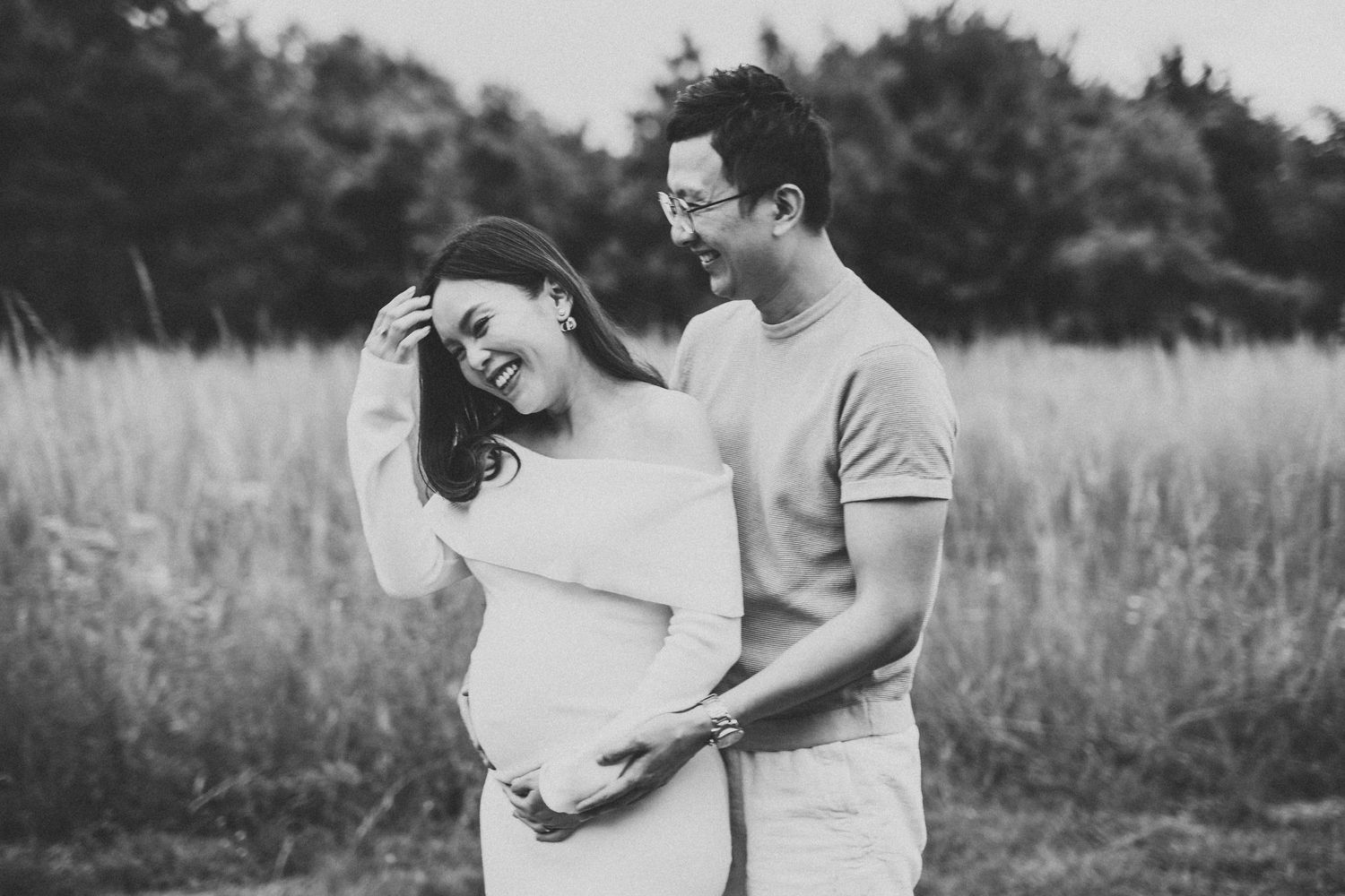 Couples maternity photo shoot outdoors in flower meadow