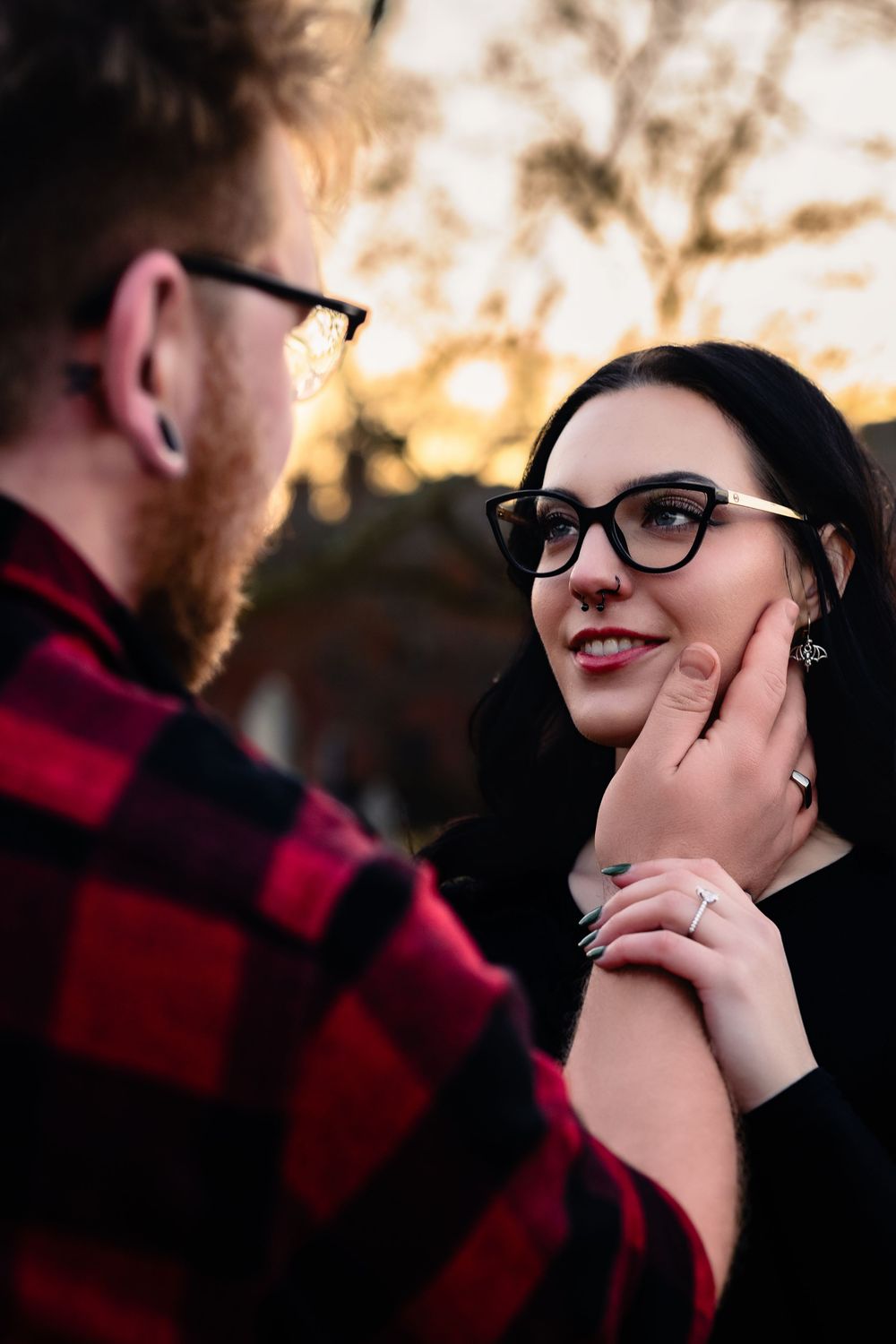 A couple shares an intimate moment during a romantic outdoor photoshoot at sunset.
