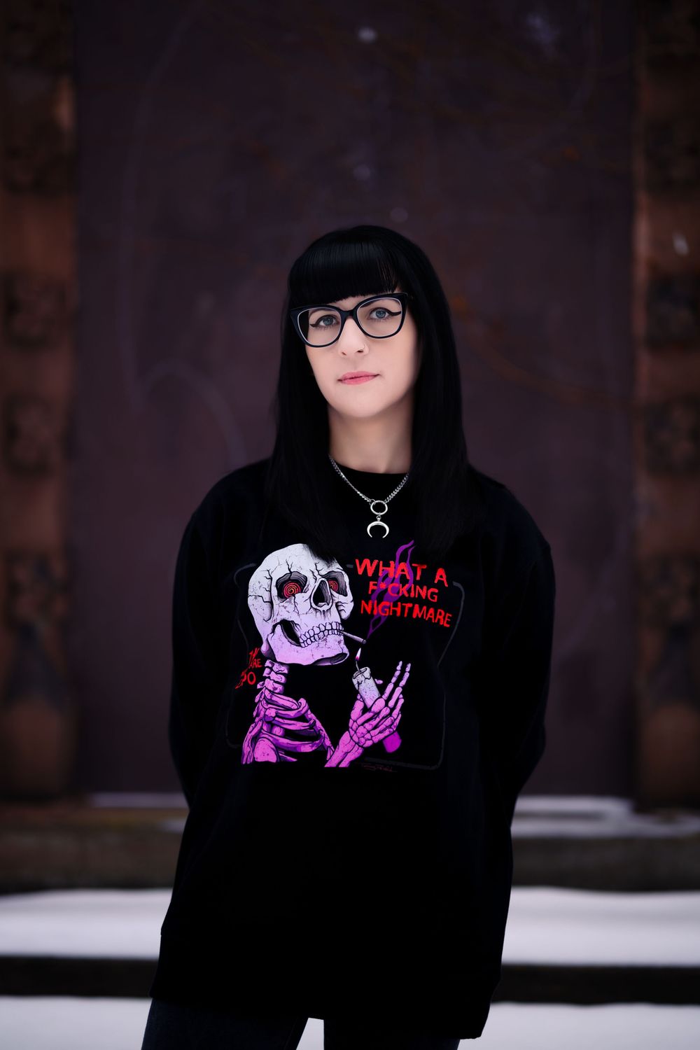 A series of photos showing a black hoodie with pink and purple skeleton designs against a snowy background.