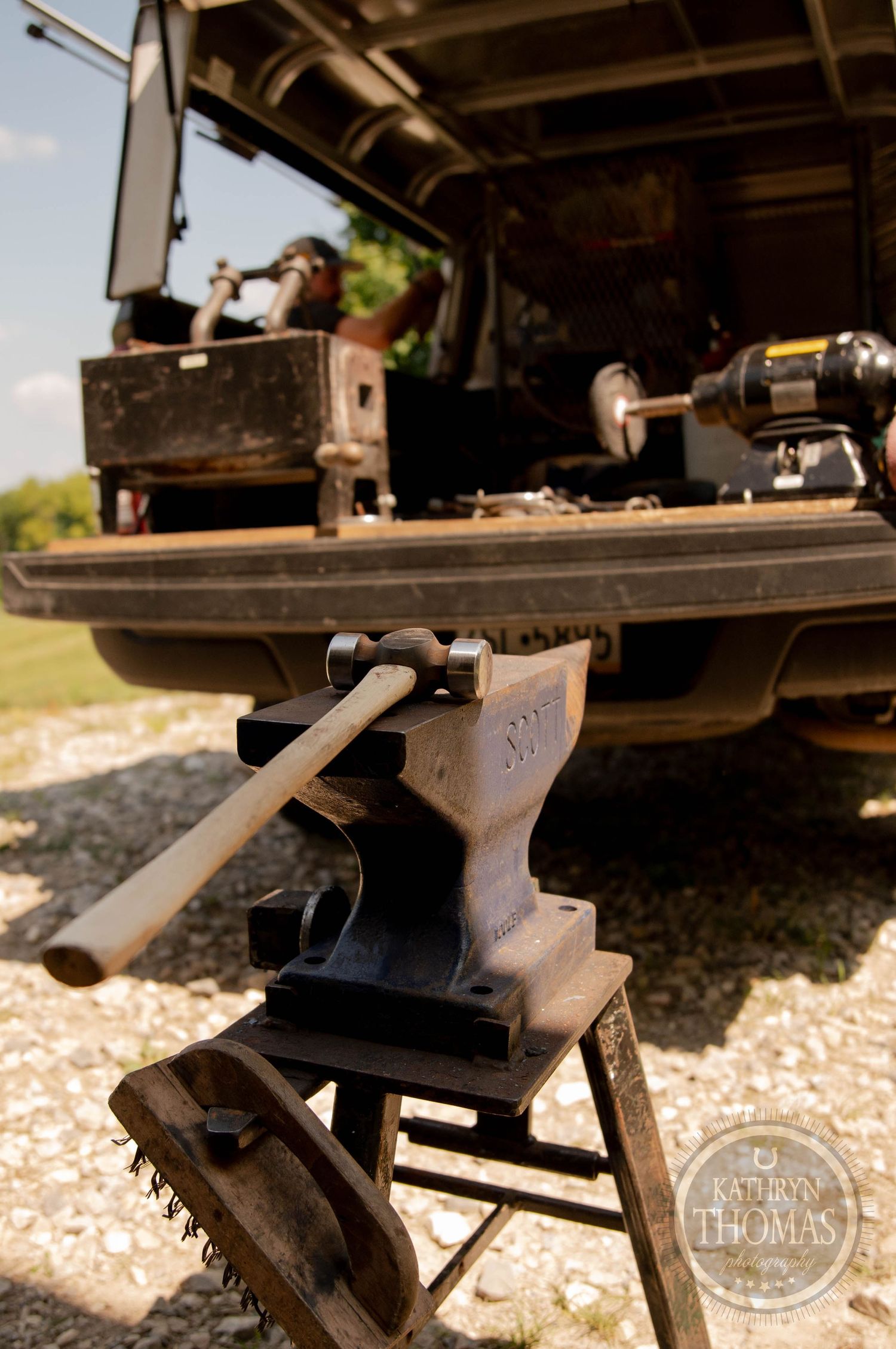Mobile blacksmith anvil and tools displayed on the back of a work truck.