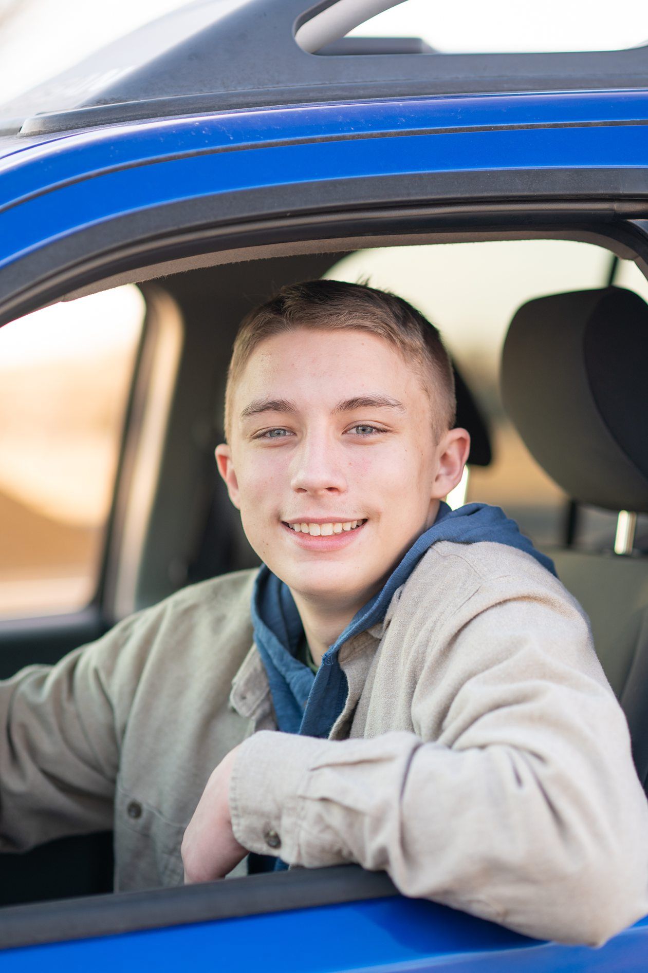 Senior guy portrait session in a late winter field and with his car by Kristi Bray Photography
