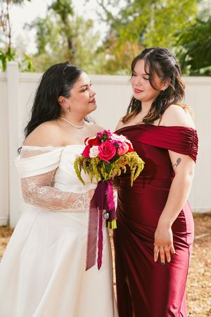 Wedding party photos featuring bridesmaids in burgundy dresses embracing the bride in a white gown.
