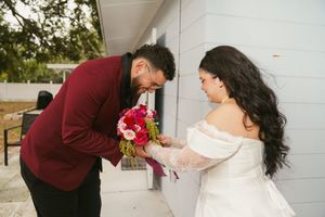 Wedding couple and bridal party dancing in a line with burgundy and white color scheme.