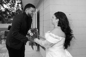A black and white wedding photo showing a couple sharing a joyful moment together.
