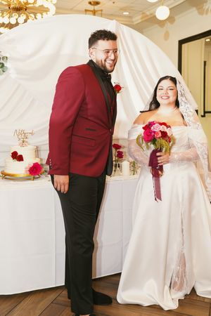 A bride and groom share a joyful moment together at their wedding reception with white draping and decor.