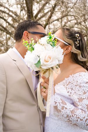 A romantic wedding moment captured with lace dress details and tender embraces in a natural outdoor setting.