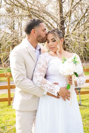 Intimate wedding portraits showing tender moments between newlyweds in white attire against a sunny outdoor backdrop.