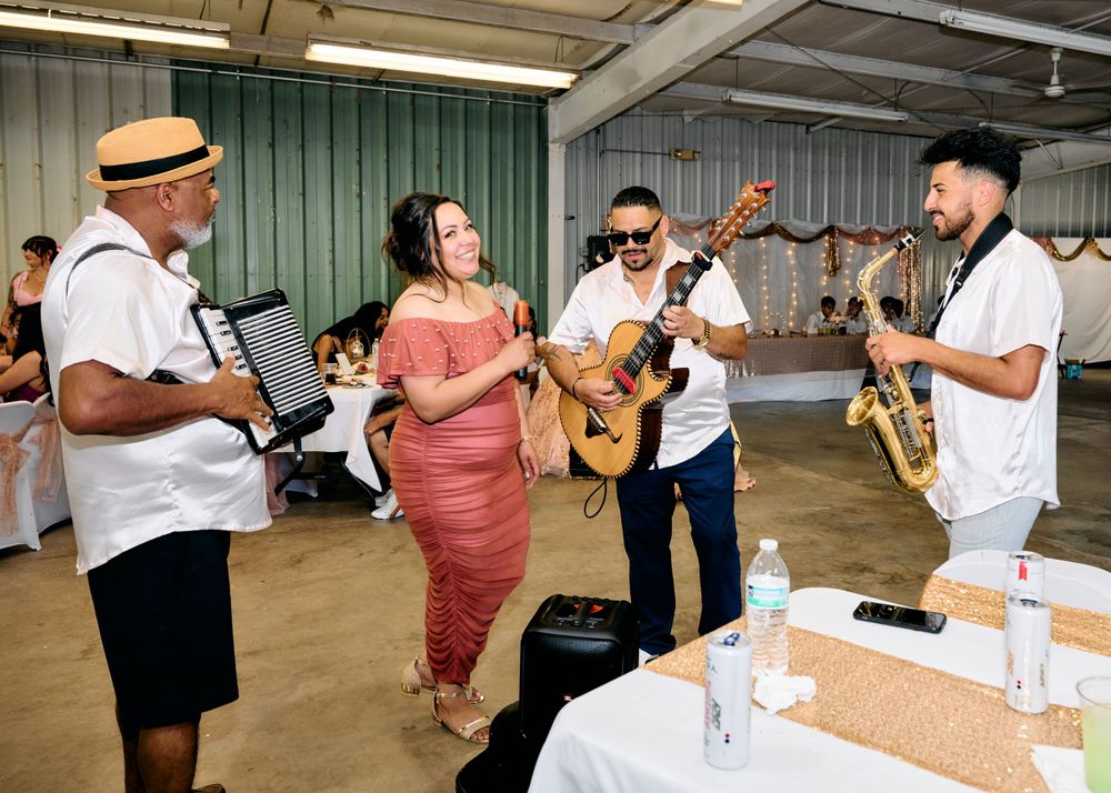 Musicians perform together in a casual indoor venue while interacting with guests during a lively performance.