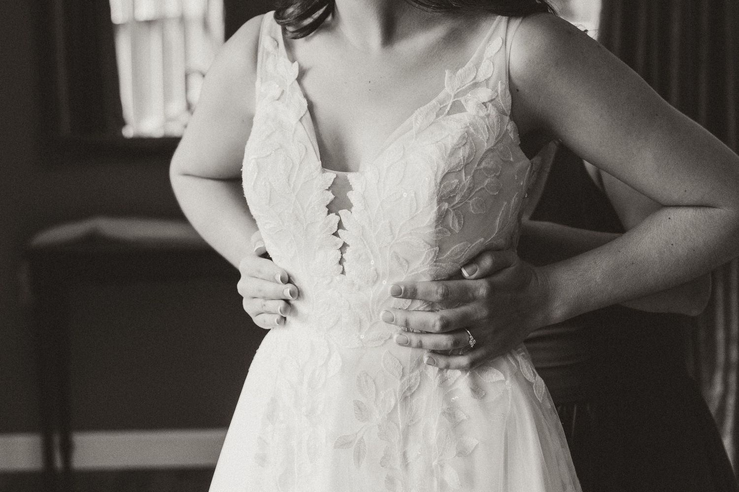 Close-up details of a white lace wedding dress with intricate patterns.