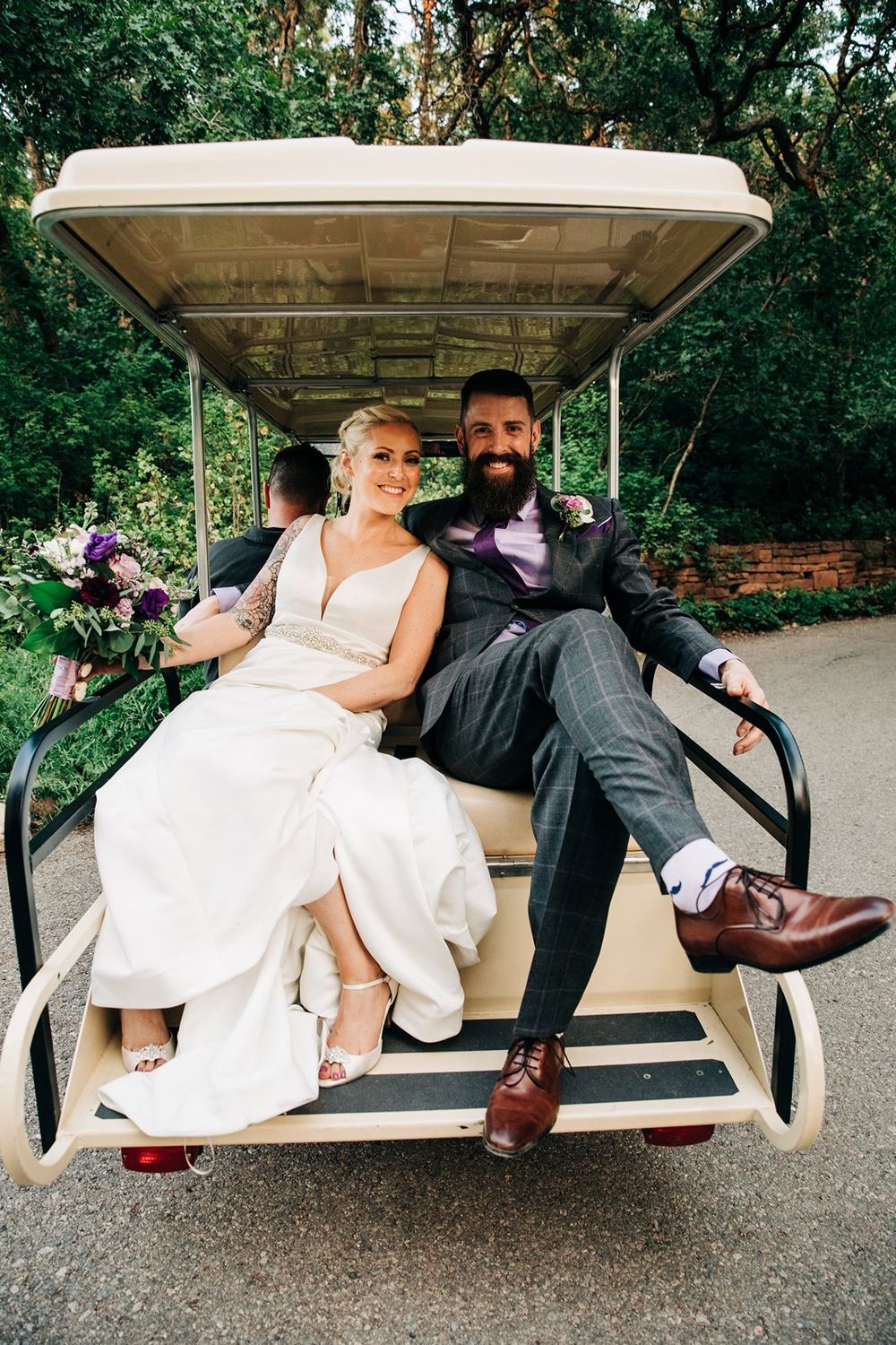 Newlyweds relaxing together on a golf cart, sharing a casual moment at their outdoor wedding.