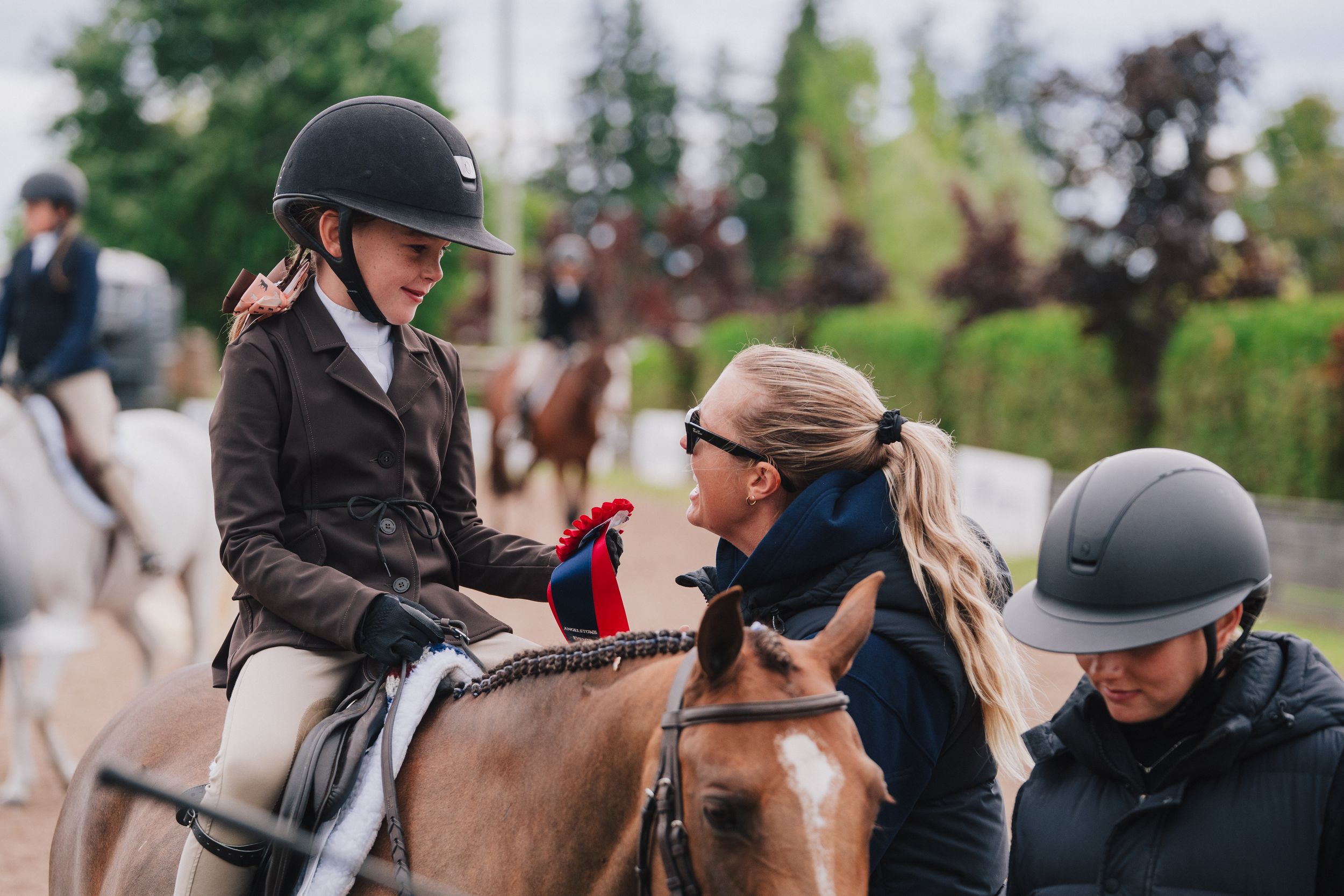 Group of riders on horses in an outdoor arena during an equestrian training or competition event.