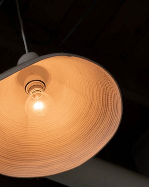 A warm-toned pendant light fixture glows against a dark ceiling.