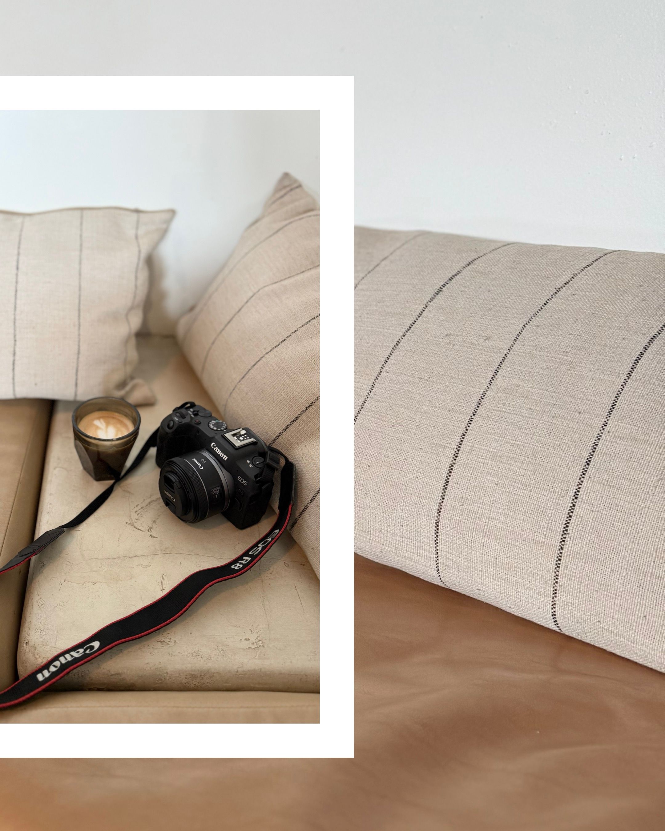 A black camera rests on beige striped pillows against a neutral background.