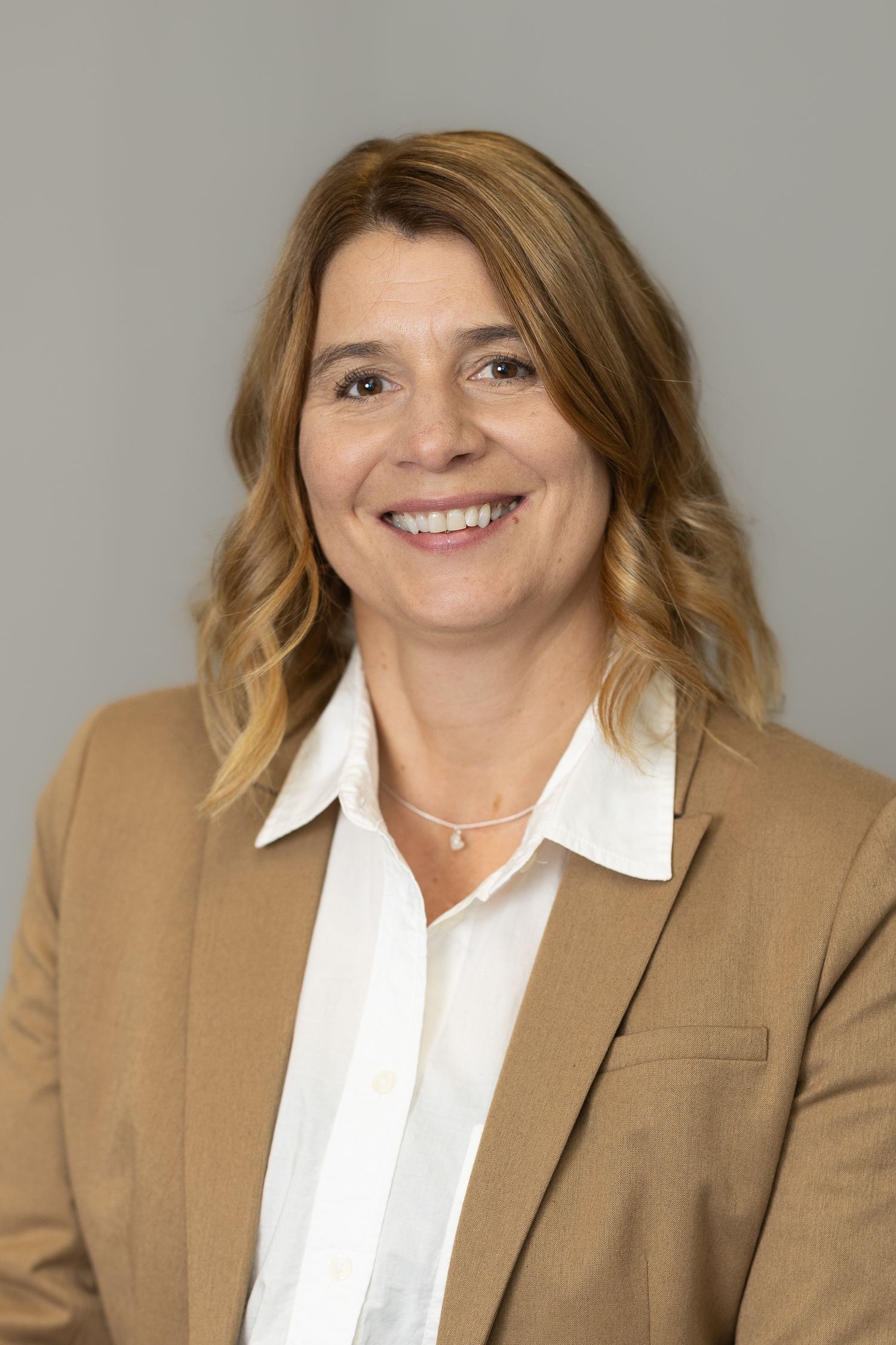 Professional headshot series showing someone in a tan blazer and white collared shirt with warm lighting against neutral backdrop.