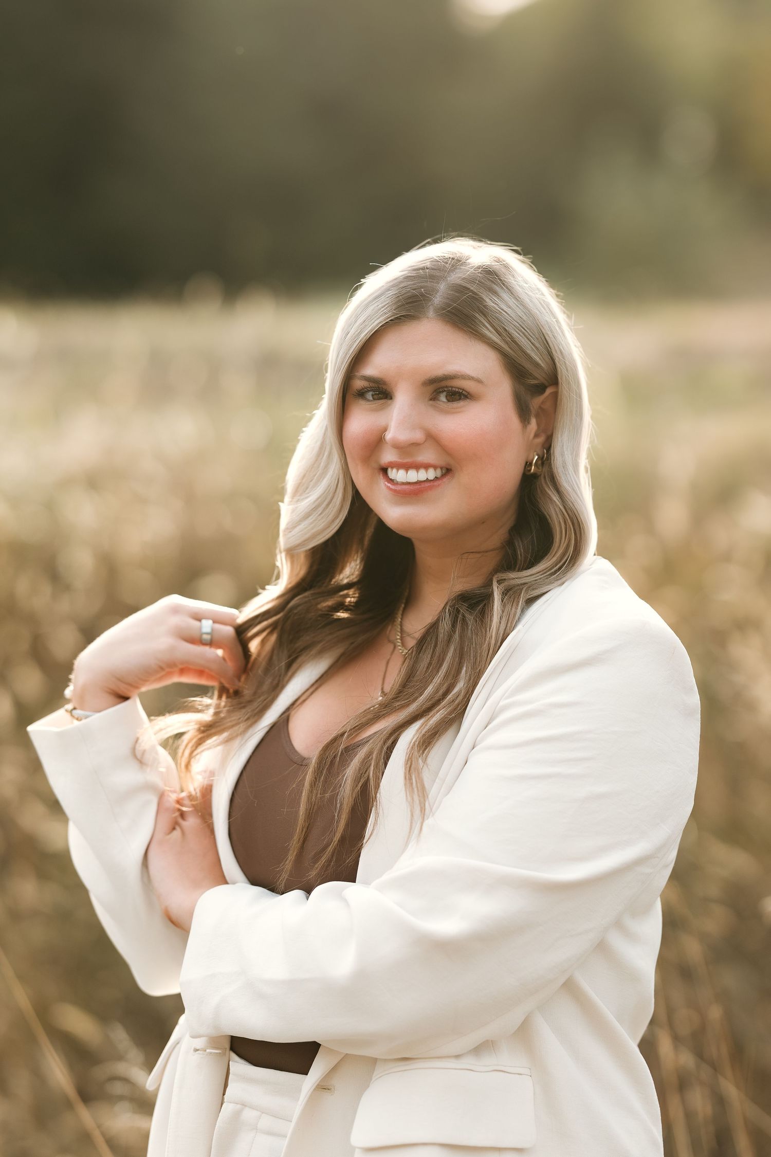 A series of four outdoor portrait photos showing someone in a white blazer posing naturally in golden sunlit field.