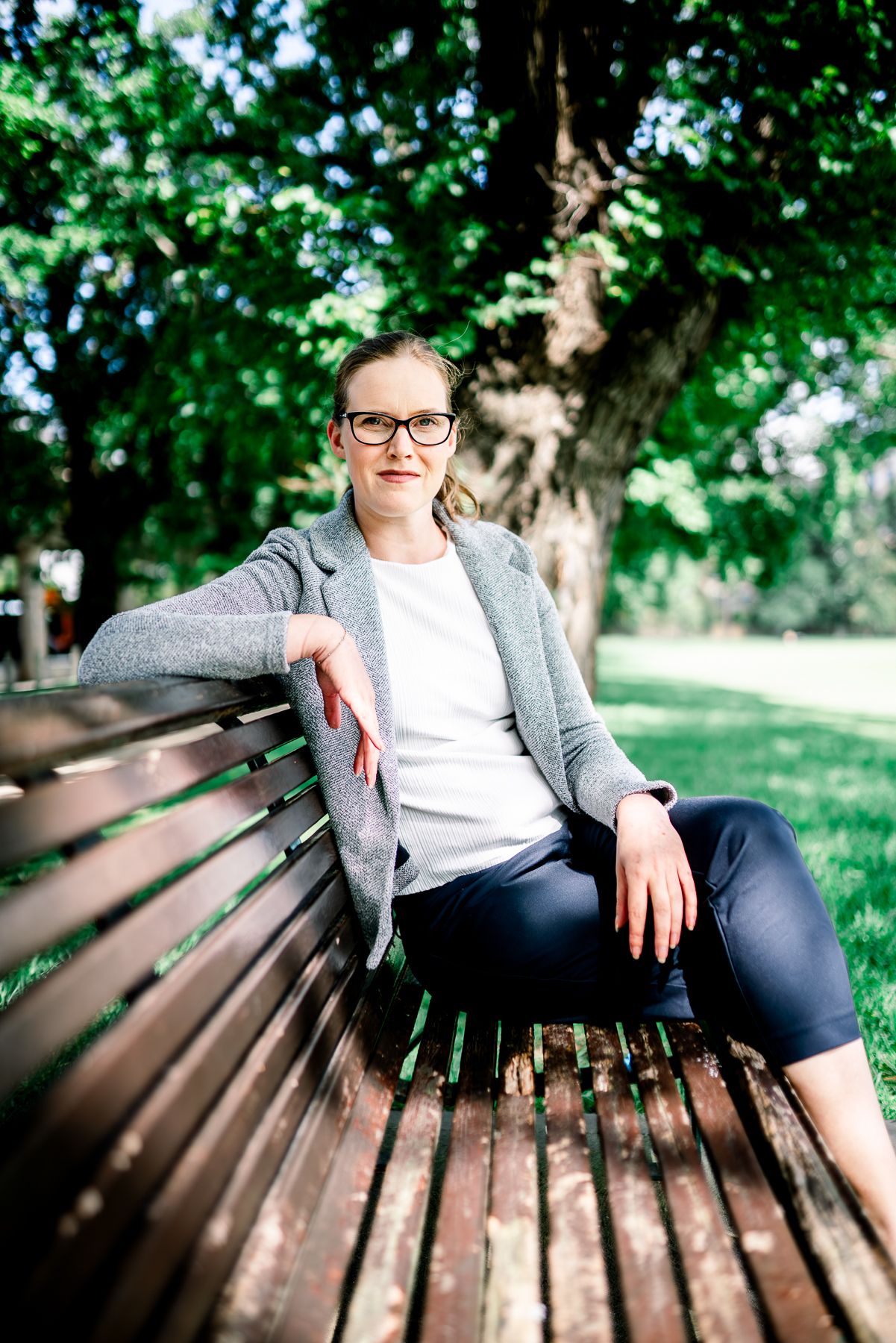 Casual portrait on wooden park bench with trees in background during a professional headshot and branding photoshoot in Melbourne.