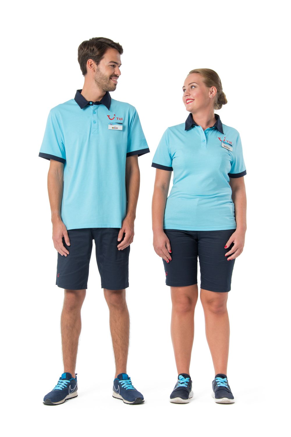 Two people wearing matching light blue polo shirts with navy trim and shorts stand together smiling in a uniform photo.